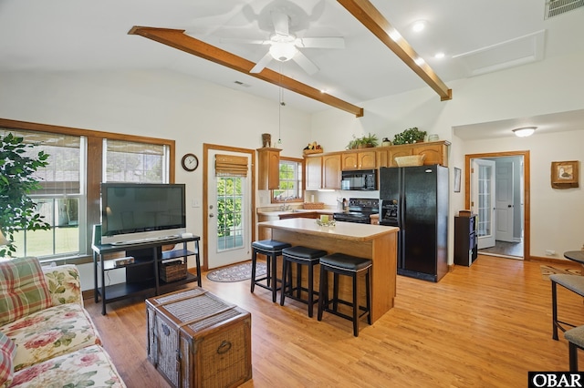 184 Tabernacle Ln, Aydlett, NC 27916 - kitchen featuring black appliances, a center island, light countertops, a breakfast bar area, and light wood finished floors
