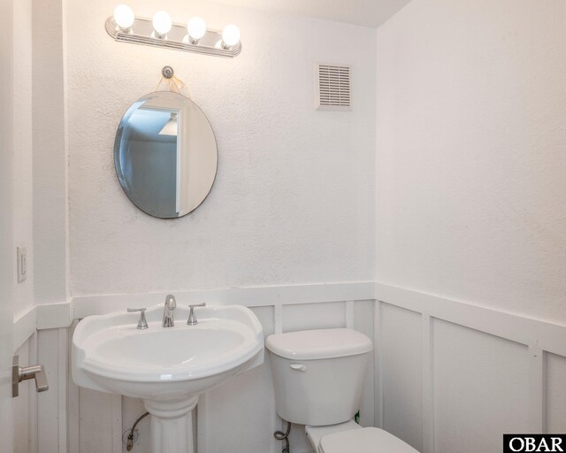 630 Skimmer Ct Lot 20, Corolla, NC 27927 - bathroom featuring wainscoting, a decorative wall, toilet, and a sink