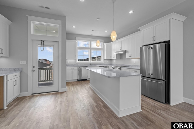 kitchen featuring visible vents, under cabinet range hood, light wood-type flooring, stainless steel appliances, and white cabinetry