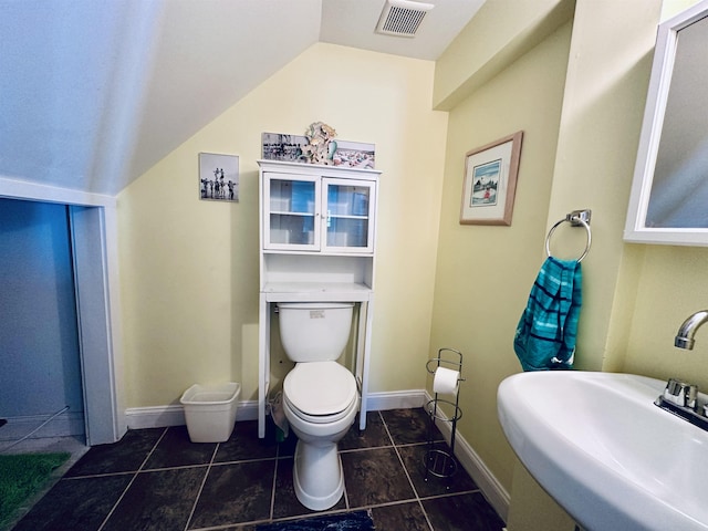 half bath featuring toilet, baseboards, visible vents, and a sink