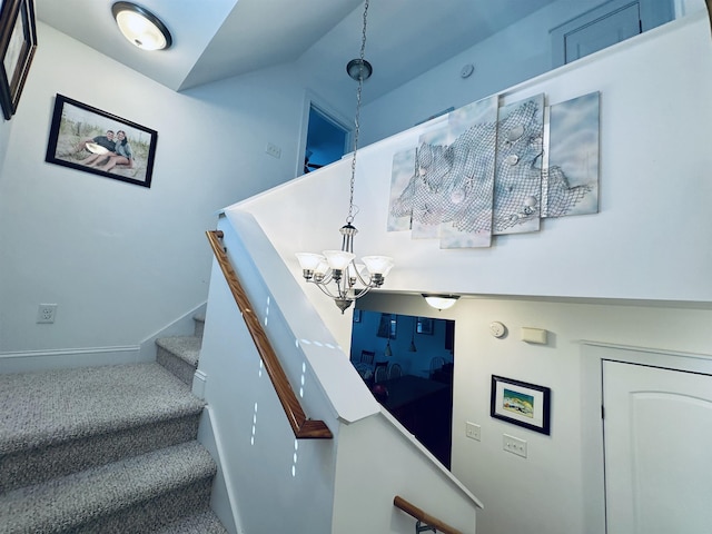 stairs with an inviting chandelier, baseboards, and vaulted ceiling