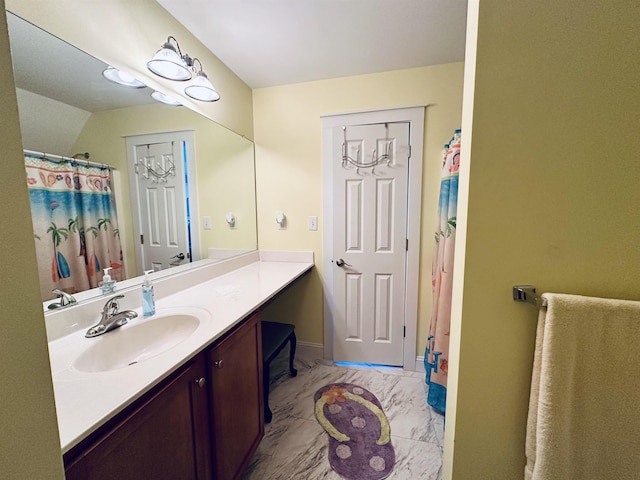 full bath featuring marble finish floor, vanity, and baseboards