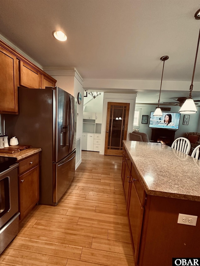 kitchen with a breakfast bar area, stainless steel appliances, hanging light fixtures, light wood-style floors, and brown cabinetry