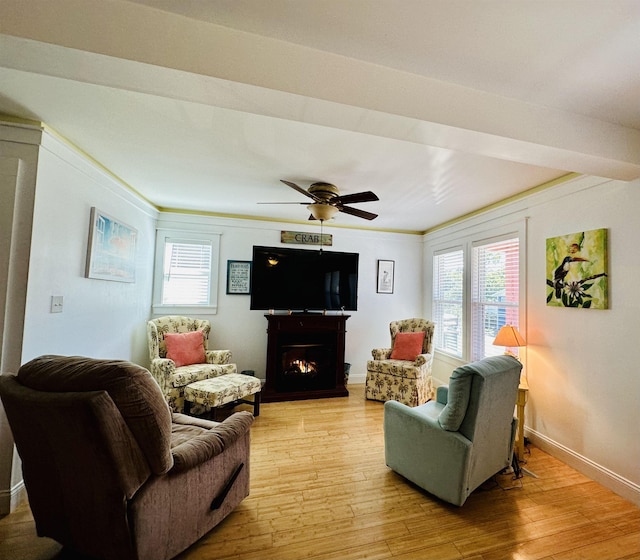 living room featuring a warm lit fireplace, light wood finished floors, and plenty of natural light