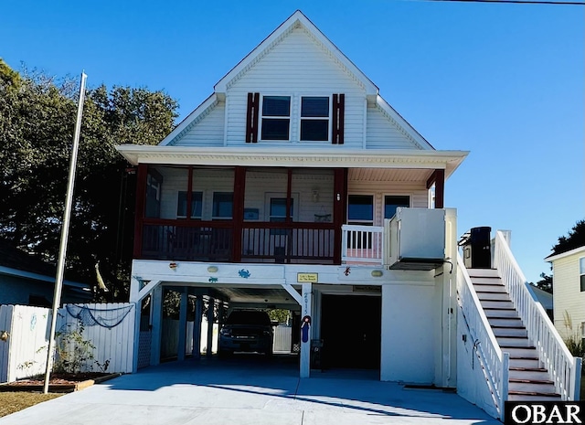 view of front of property with stairs, a porch, a carport, and concrete driveway