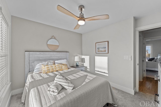 bedroom with light carpet, ceiling fan, and baseboards