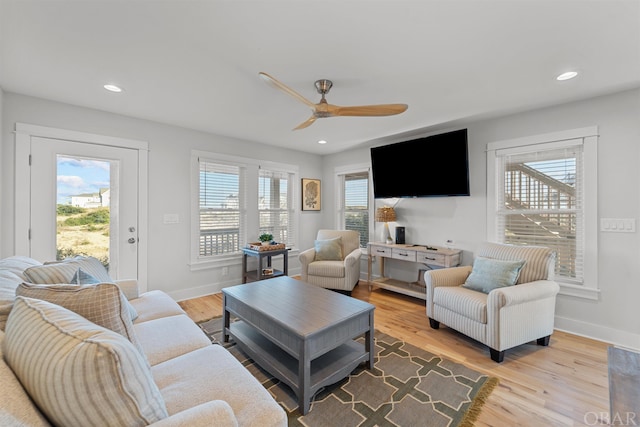 living room with light wood-type flooring, baseboards, and recessed lighting