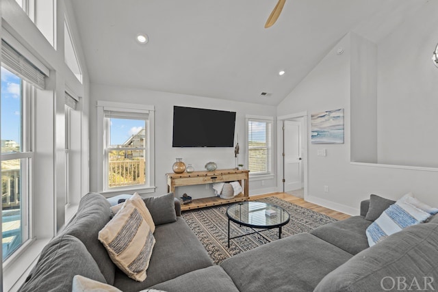 living room with high vaulted ceiling, recessed lighting, light wood-style flooring, and baseboards