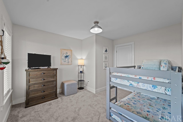 bedroom with light carpet, multiple windows, and baseboards