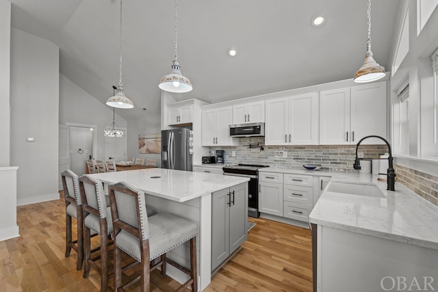 kitchen with white cabinetry, stainless steel appliances, and a center island