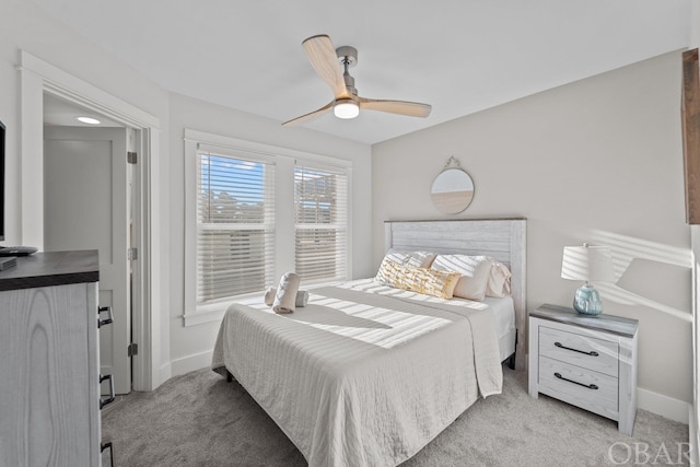 bedroom featuring light carpet, ceiling fan, and baseboards