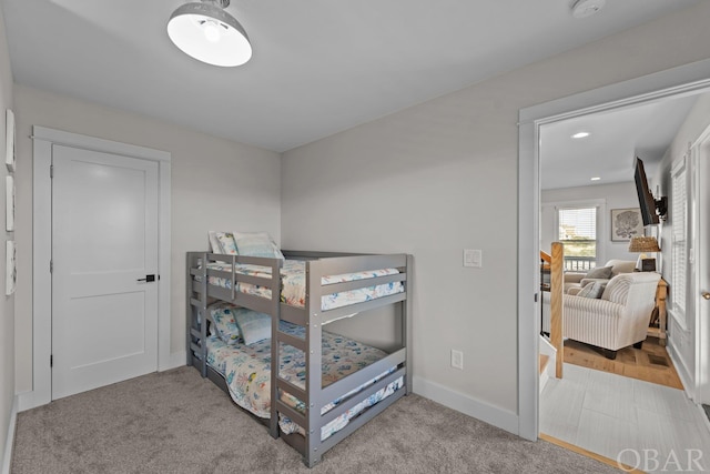 bedroom featuring baseboards and light colored carpet