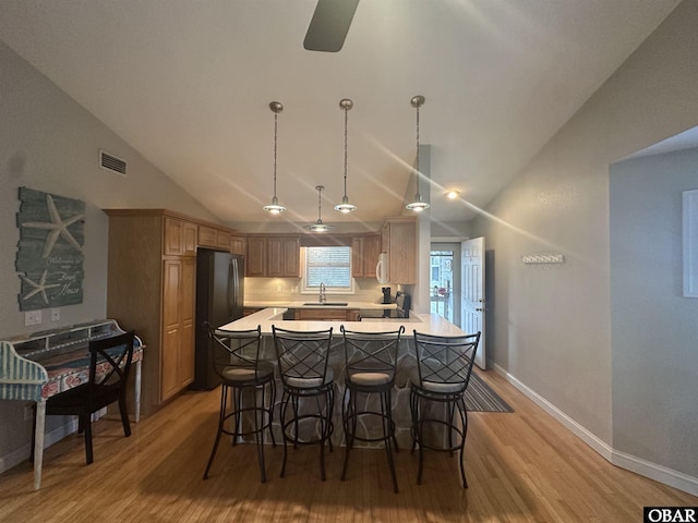 kitchen featuring light wood-type flooring, light countertops, a sink, and visible vents