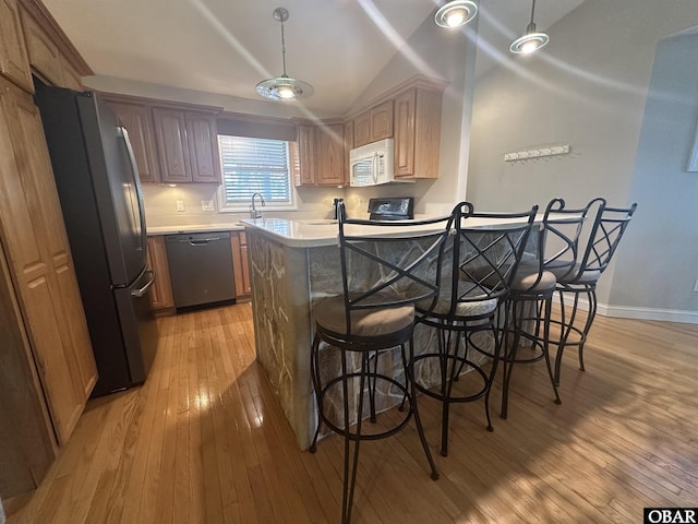 kitchen featuring dishwasher, white microwave, stove, freestanding refrigerator, and light countertops