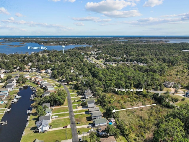 drone / aerial view featuring a forest view, a residential view, and a water view