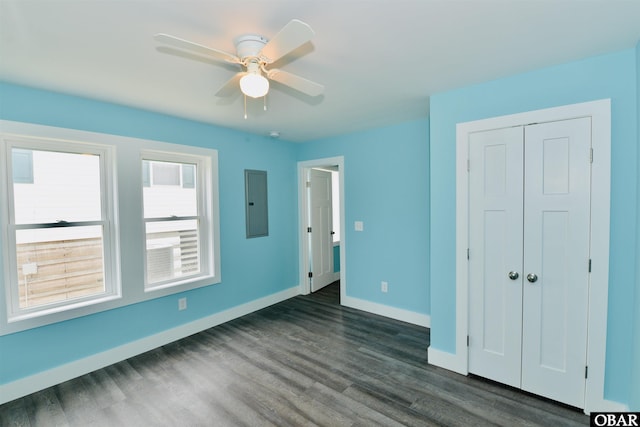unfurnished bedroom with ceiling fan, dark wood finished floors, a closet, electric panel, and baseboards