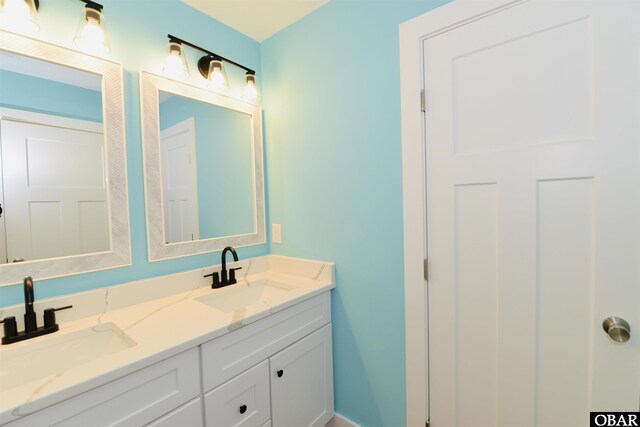 bathroom featuring a sink and double vanity