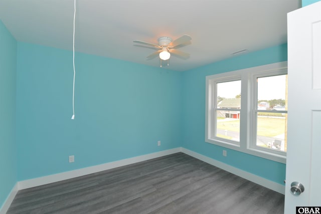 unfurnished room with a ceiling fan, baseboards, dark wood finished floors, and visible vents