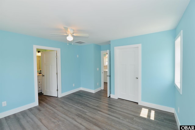 spare room featuring visible vents, baseboards, a ceiling fan, and wood finished floors