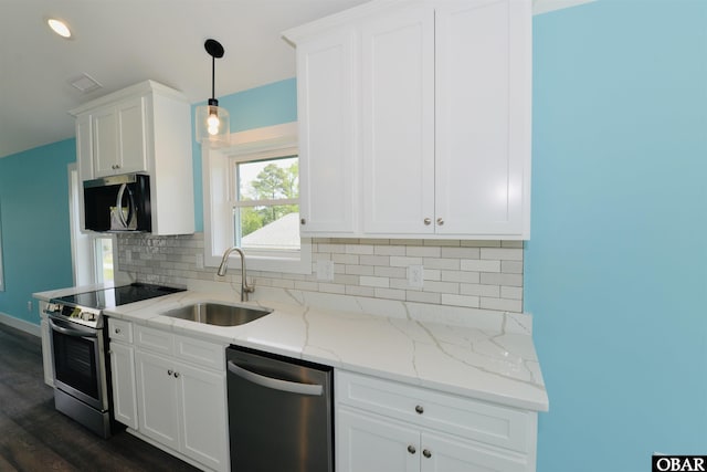 kitchen featuring dark wood-type flooring, white cabinets, a sink, stainless steel appliances, and backsplash