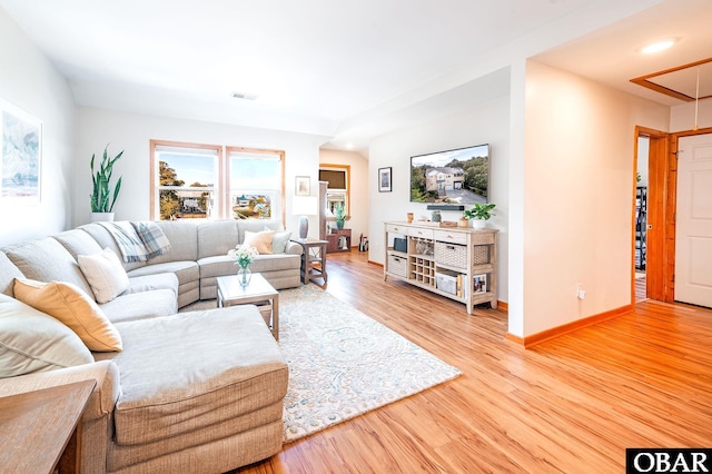 living room featuring visible vents, wood finished floors, attic access, and baseboards