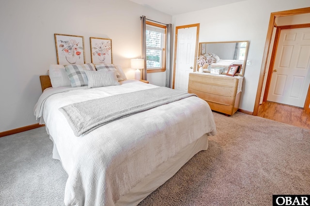 carpeted bedroom with a closet and baseboards