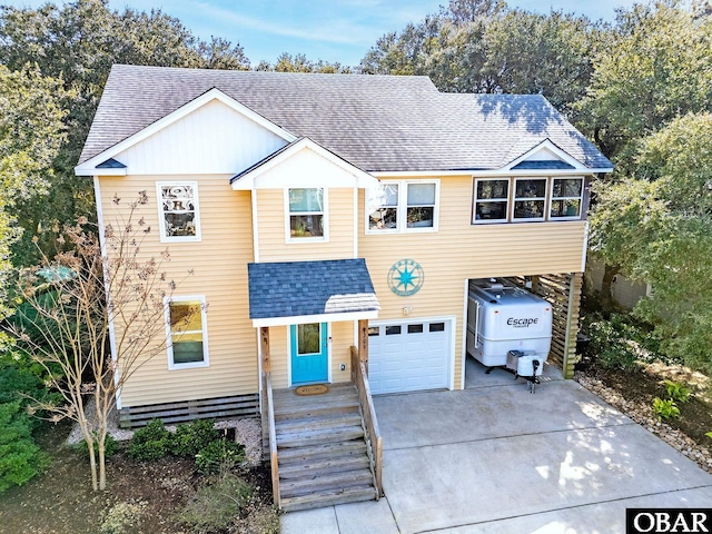 view of front of home with a garage, concrete driveway, roof with shingles, and a carport