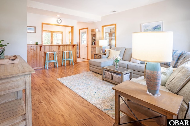 living area with visible vents and wood finished floors