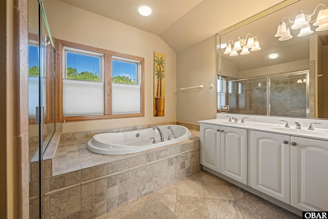 full bath with a garden tub, double vanity, vaulted ceiling, a stall shower, and a sink