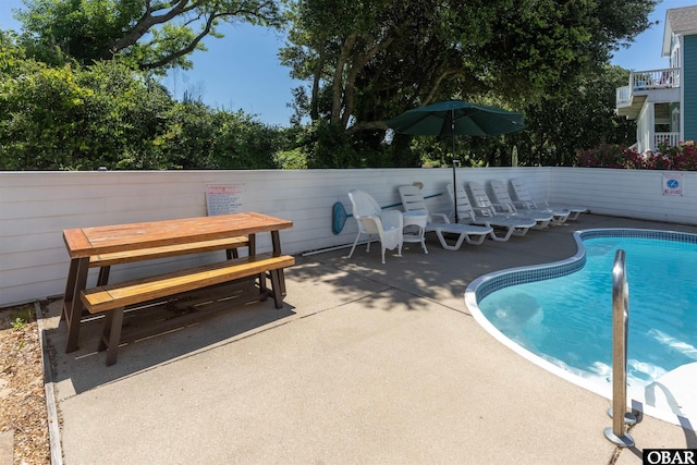 community pool featuring outdoor dining space, a patio, and fence