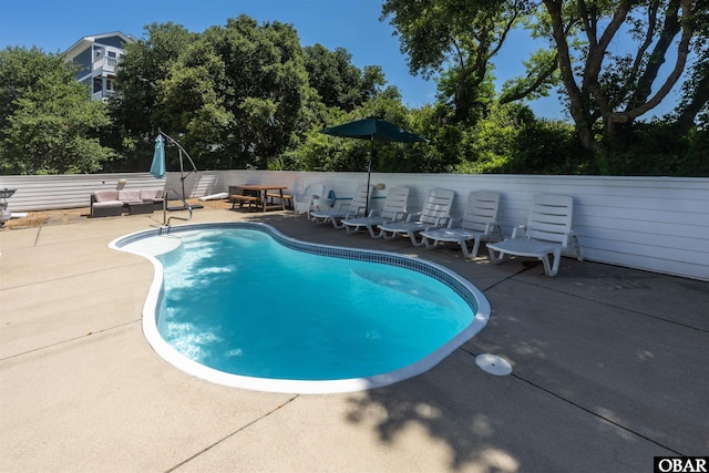 view of swimming pool with a fenced in pool and a patio