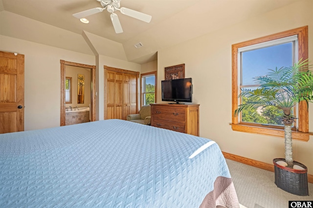 bedroom with visible vents, lofted ceiling, ensuite bathroom, carpet floors, and baseboards
