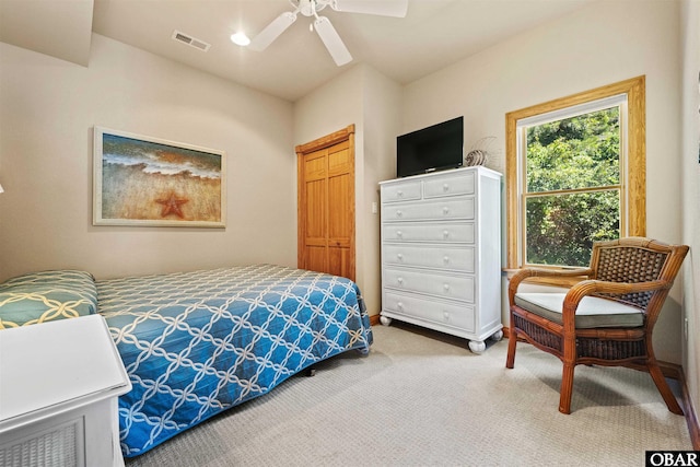 carpeted bedroom featuring visible vents, a closet, and a ceiling fan