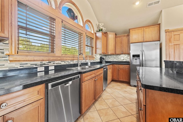 kitchen with a sink, lofted ceiling, visible vents, and stainless steel appliances