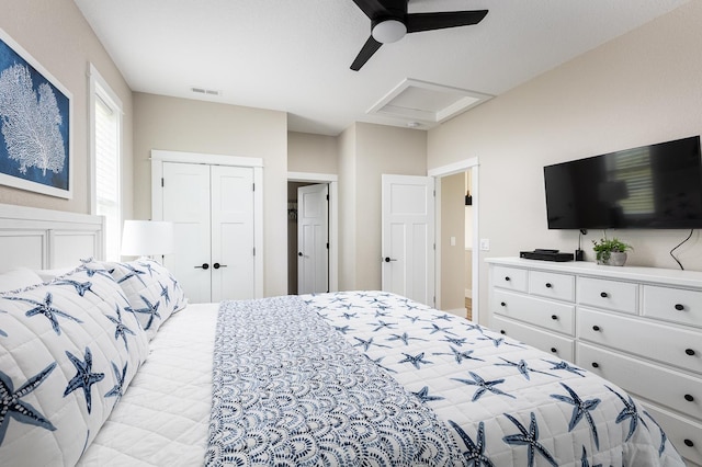 bedroom featuring attic access, a closet, visible vents, and ceiling fan