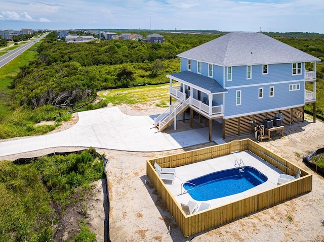 pool featuring a fenced backyard, stairway, and central air condition unit