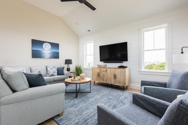 living area featuring a healthy amount of sunlight, a ceiling fan, wood finished floors, and lofted ceiling