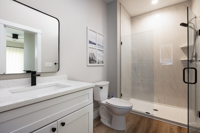 full bath with vanity, a shower stall, toilet, and wood finished floors