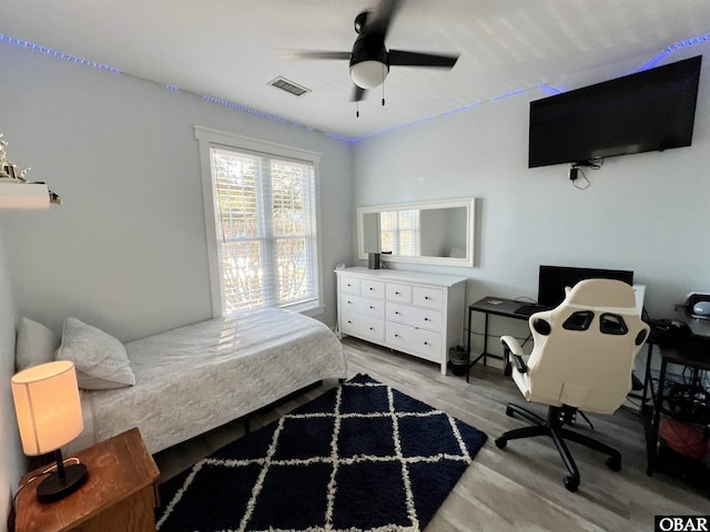 bedroom featuring a ceiling fan, visible vents, and light wood-style flooring