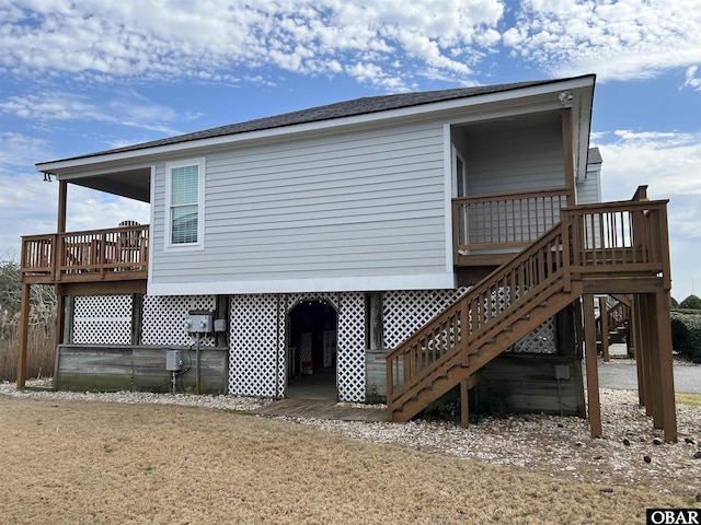 rear view of property featuring stairs and a deck