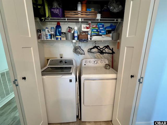 laundry area with laundry area, light wood finished floors, washing machine and clothes dryer, and visible vents