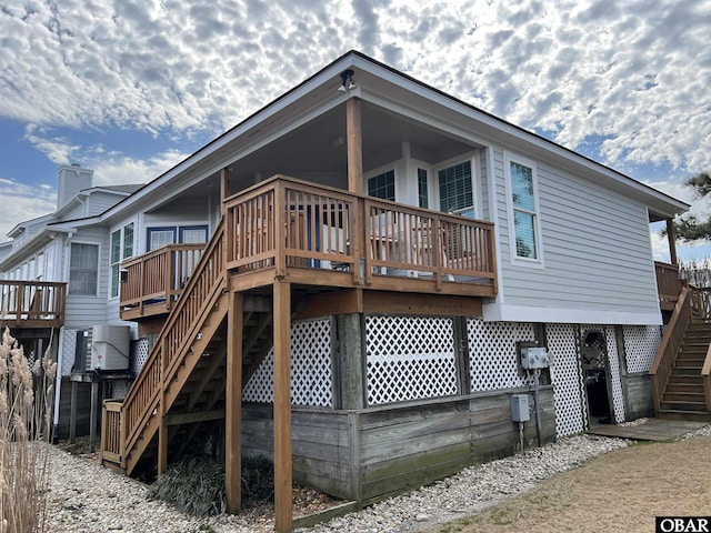 back of property with a deck, ac unit, and stairway