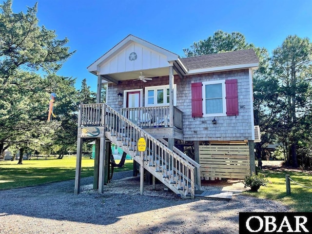 104 Sand Dollar Rd Lot # 23, Ocracoke, NC 27960 - view of front of house with ceiling fan, a front lawn, a porch, stairs, and a shingled roof