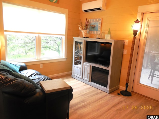 104 Sand Dollar Rd Lot # 23, Ocracoke, NC 27960 - living area featuring a wall unit AC, light wood finished floors, and wooden walls