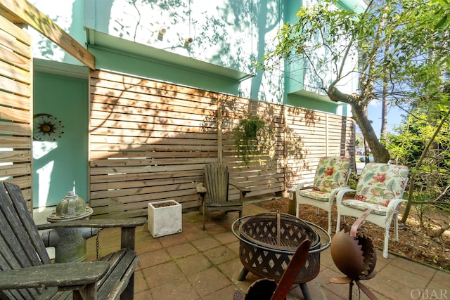 view of patio featuring a fire pit and fence