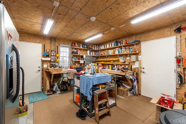 interior space with stainless steel fridge and a workshop area