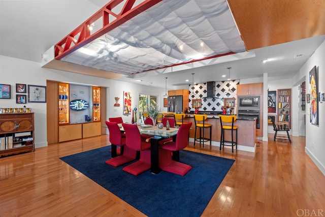 dining space with light wood-style flooring and baseboards