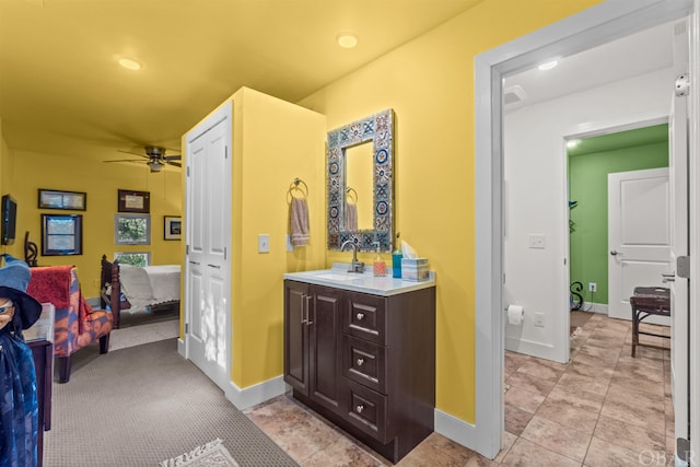 ensuite bathroom featuring baseboards, a ceiling fan, connected bathroom, and vanity