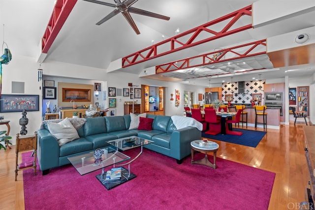 living room featuring ceiling fan, wood finished floors, and wet bar