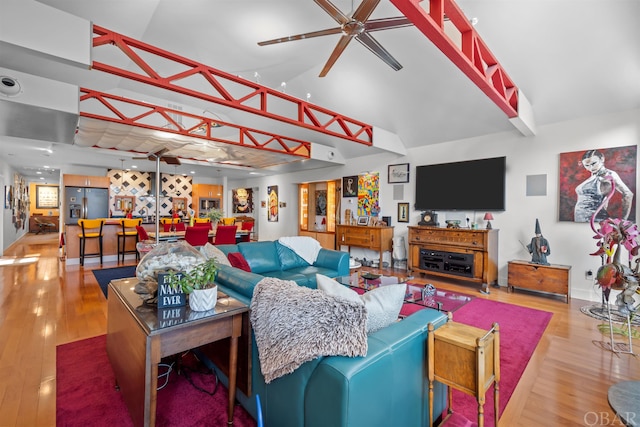 living area featuring high vaulted ceiling, ceiling fan, baseboards, and wood finished floors